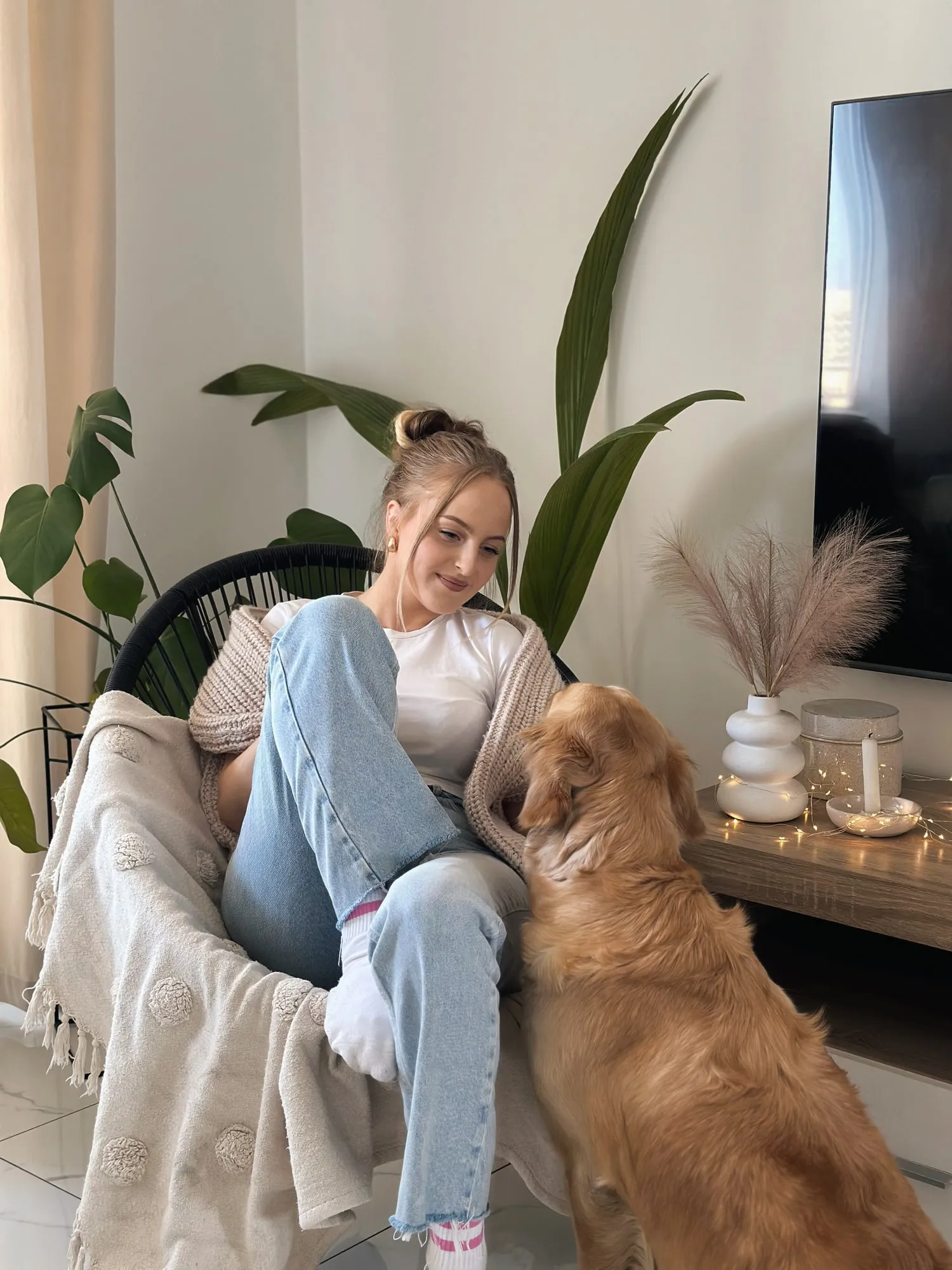 Kobieta z psem golden retriever na kanapie w domowym wnętrzu