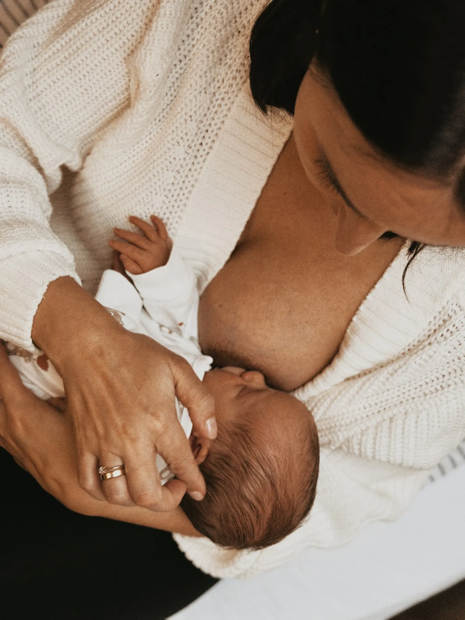 Mama tuląca noworodka — sesja noworodkowa w domu