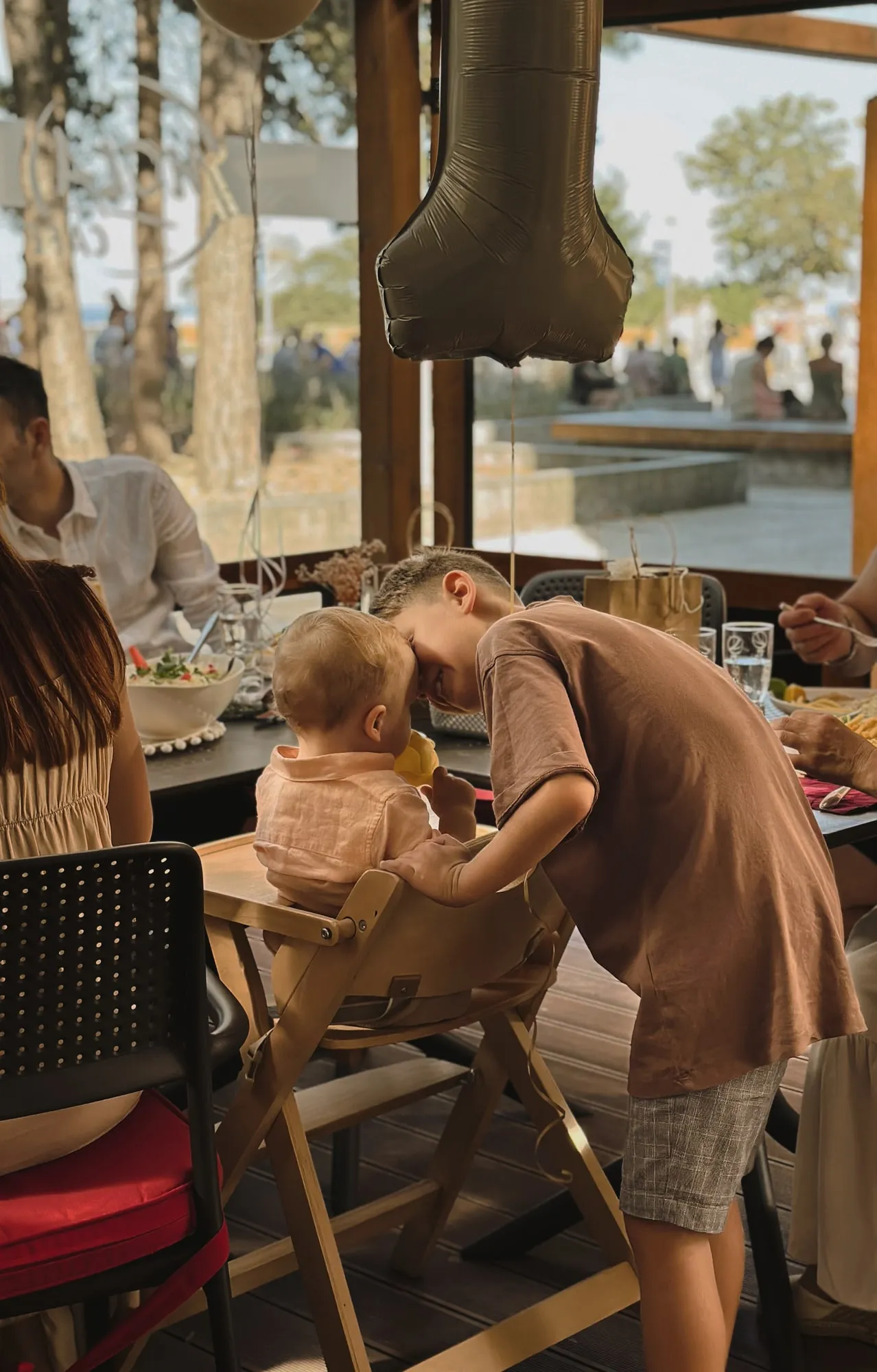 Rodzic z dzieckiem przy stole w restauracji — sesja lifestyle